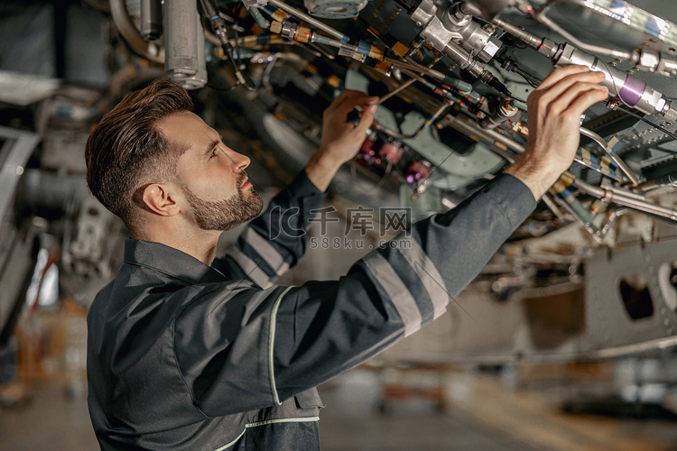 在机库修理飞机的男性维修技术员