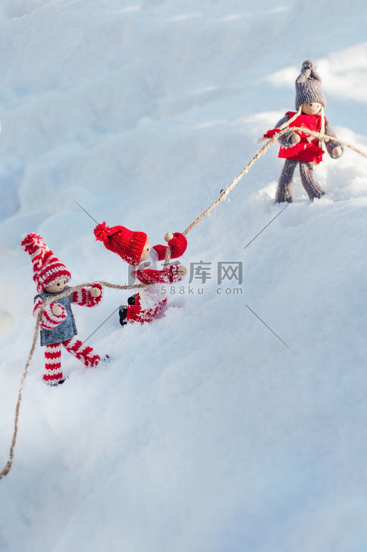 雪坡上的木娃娃紧紧抓住绳子