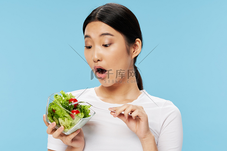 女人拿着一杯沙拉吃减肥瘦身