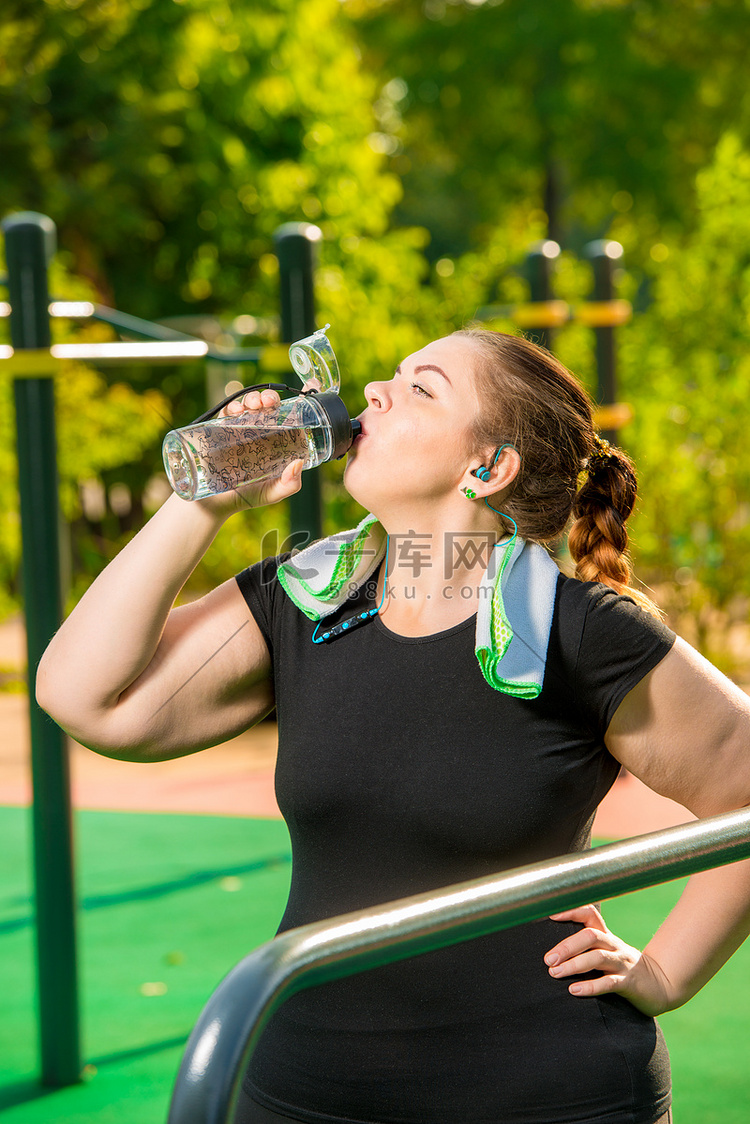 大号女孩在运动后从瓶子里喝干净