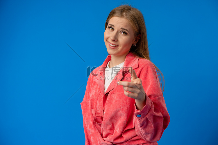 蓝色背景中的年轻女人用手指指着