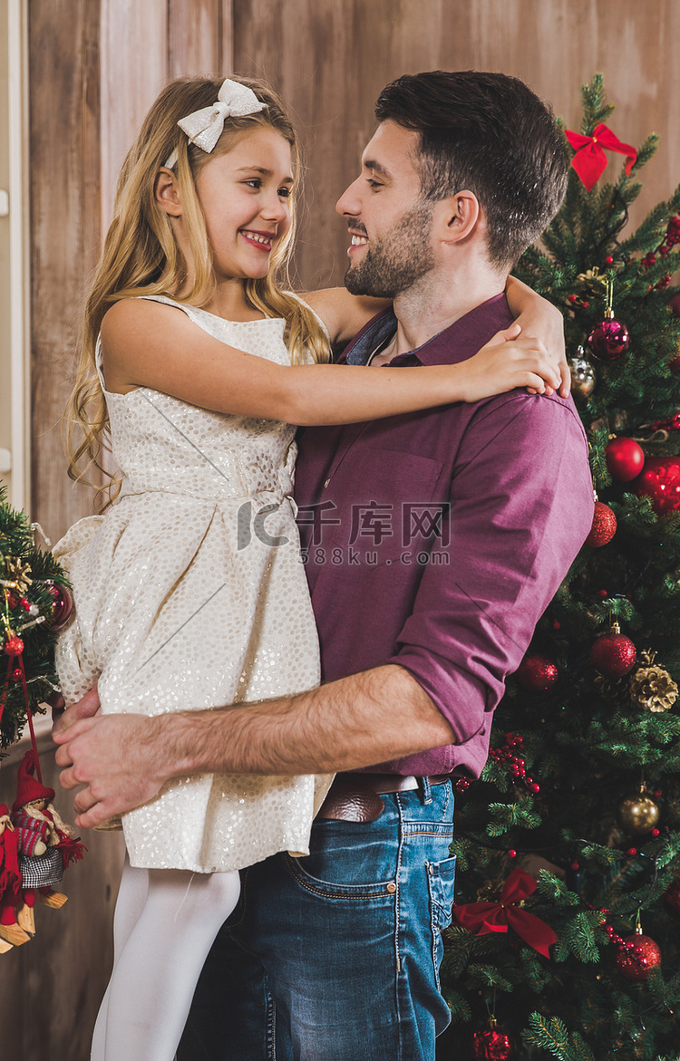 快乐的父亲和女儿在圣诞树附近