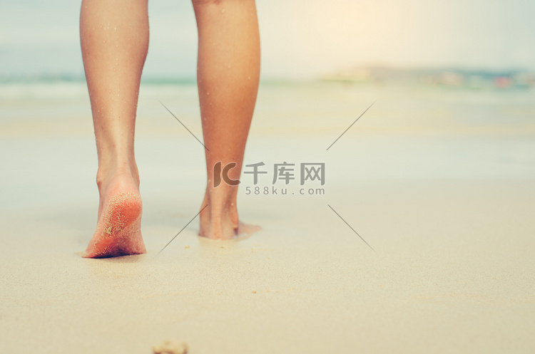 旅行者赤脚踩在沙滩上。