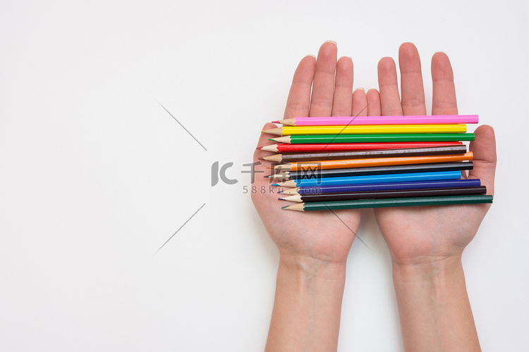 女手手里拿着一打铅笔，手向右，