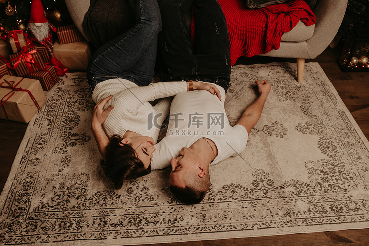 一对夫妇躺在沙发附近的地板上，
