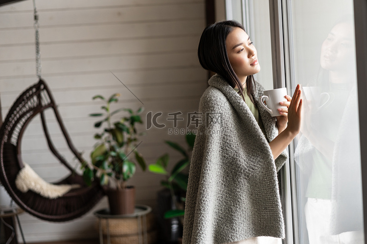浪漫的亚洲女人摸着窗户，用体贴