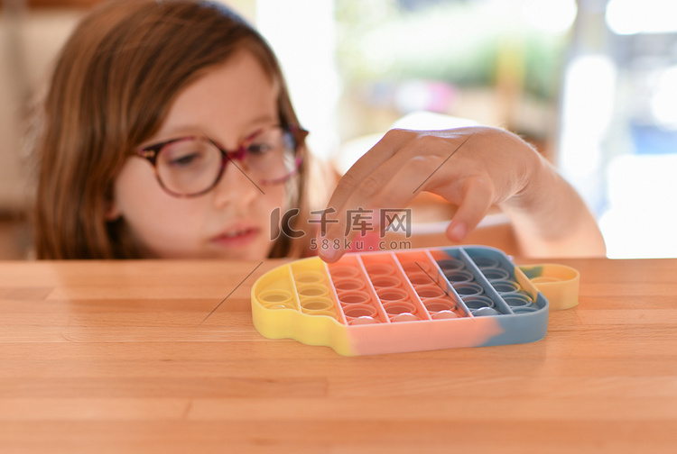 一个女孩玩着彩色抗压感官玩具 