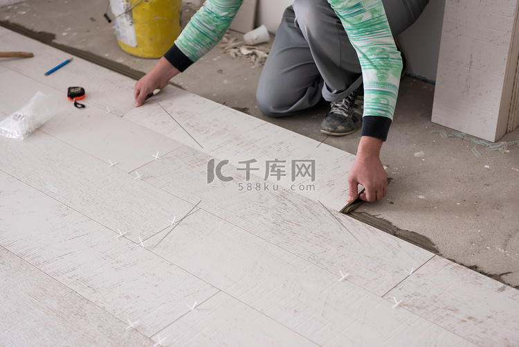 工人在地板上安装陶瓷木纹瓷砖
