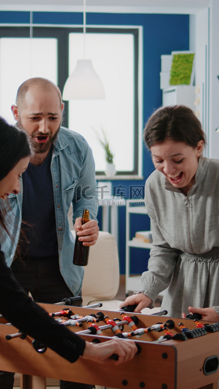 快乐的女人在足球桌上赢得比赛来