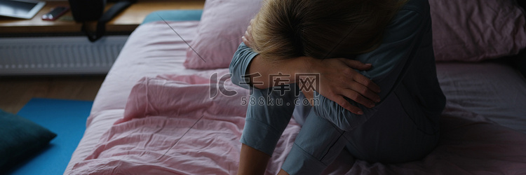 孤独悲伤的女人坐在床上特写