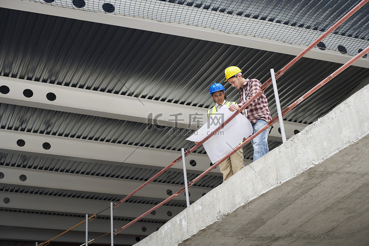 施工经理和工人在现场检查建筑平