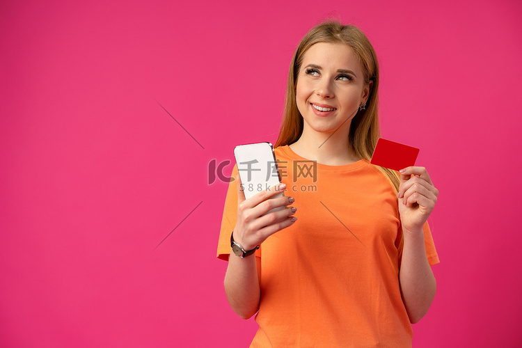 粉红色背景中使用手机的年轻女性
