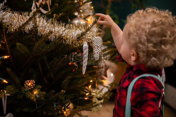 一个两岁的金色卷发男孩在圣诞树