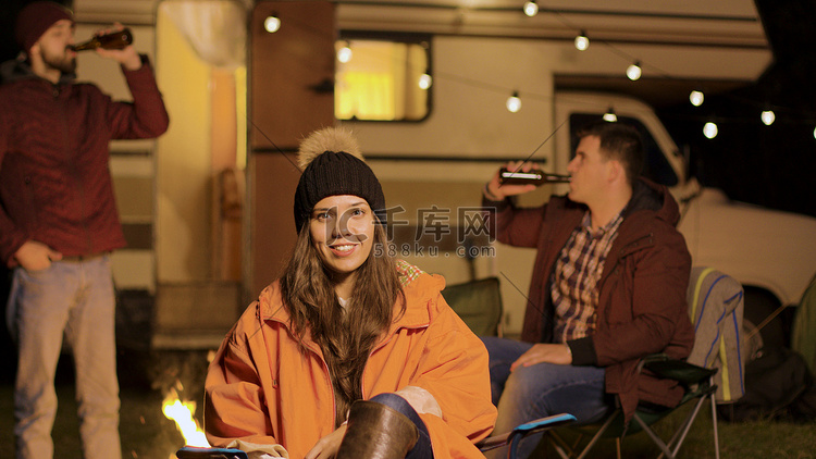 秋天寒冷的夜晚坐在野营椅上的女