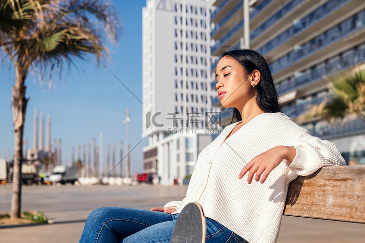 坐在街边长椅上放松的年轻女子