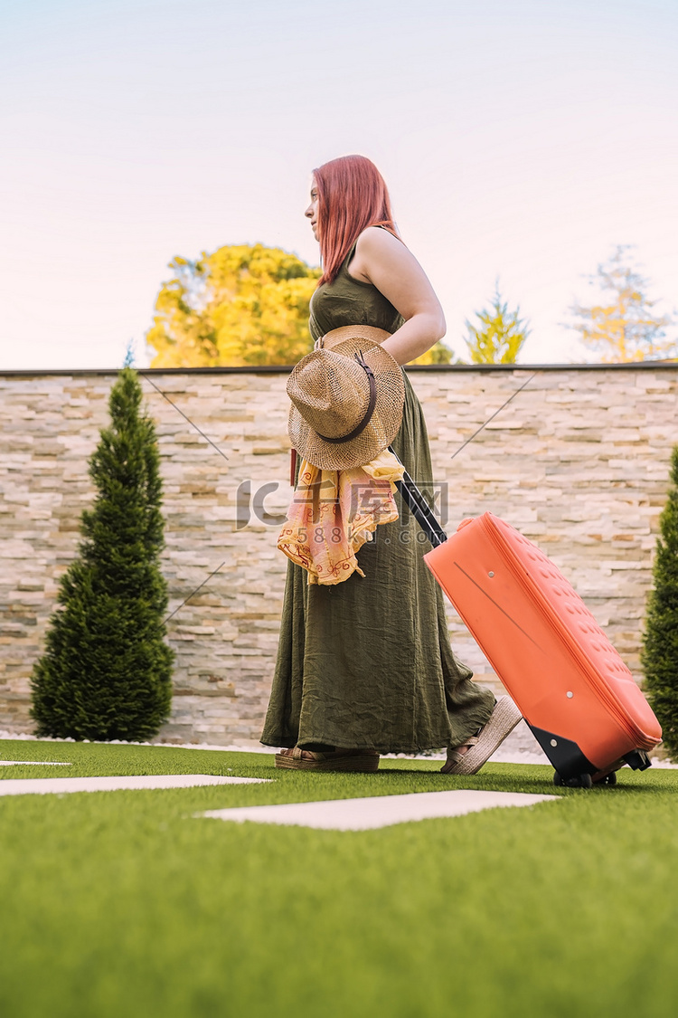 年轻的女旅行者，带着带轮子的手