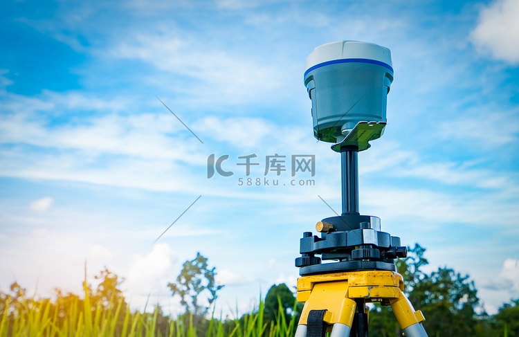 蓝天和稻田背景的 GPS 测量仪器。