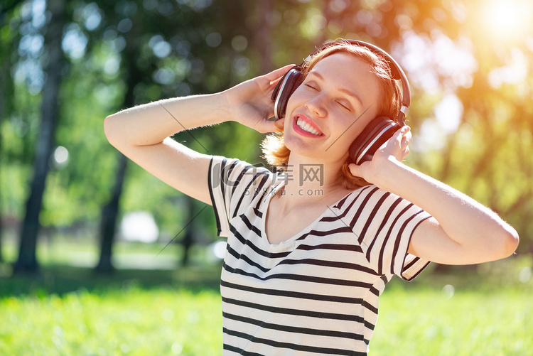 年轻女子恰好在夏季公园里有音乐