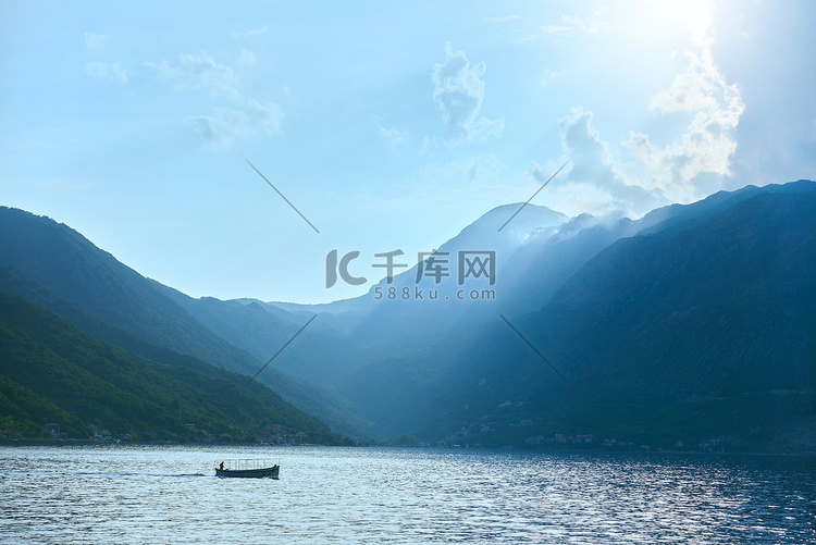 黑山山背景下，一艘载着渔民的船