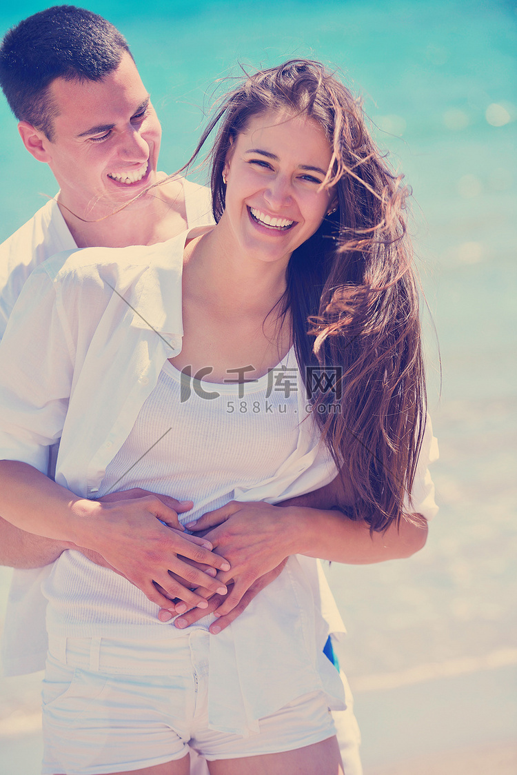 幸福的情侣在沙滩上玩得开心