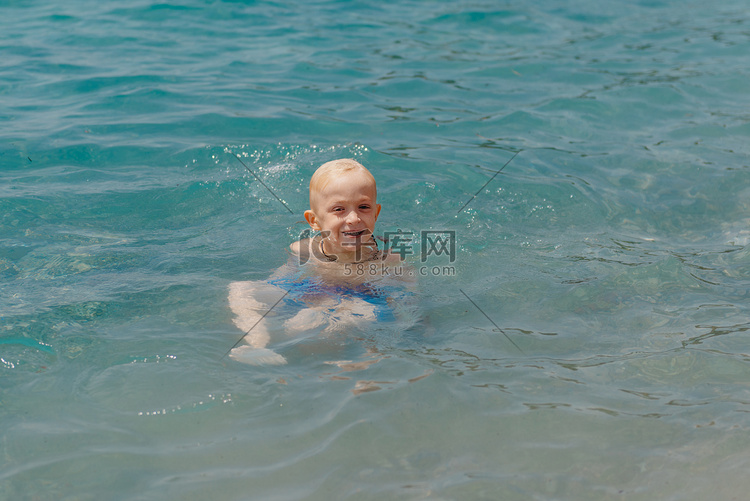 孩子在热带度假村的公海上学习游