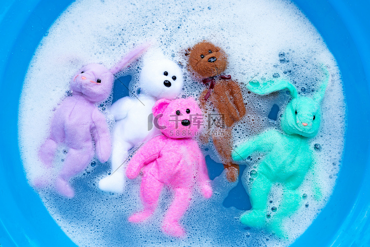 将兔子娃娃和玩具泰迪熊浸泡在洗