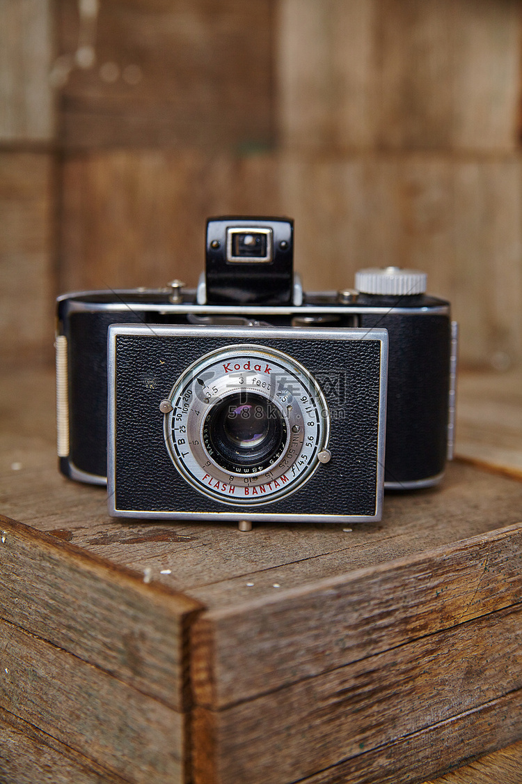古董胶片相机坐在木箱上，用闪光