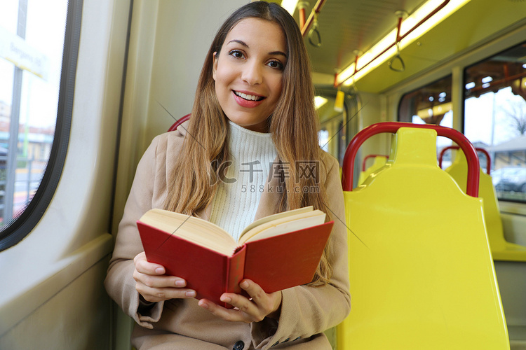 坐在电车里的美丽年轻女子在看书