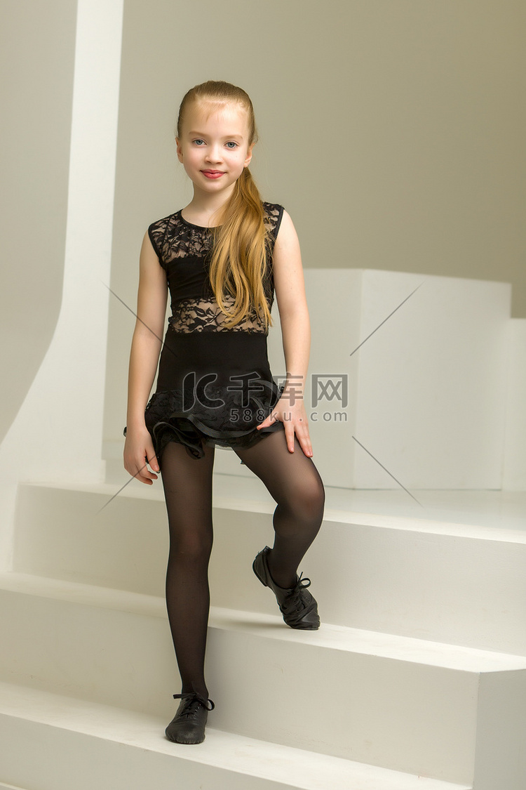 穿着舞蹈服装的小女孩坐在楼梯上