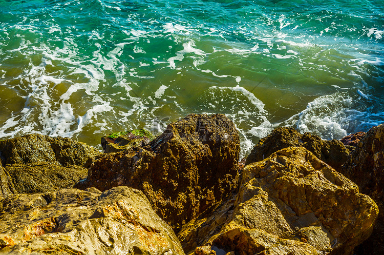 炎热的一天，海水冲击岩石海岸，