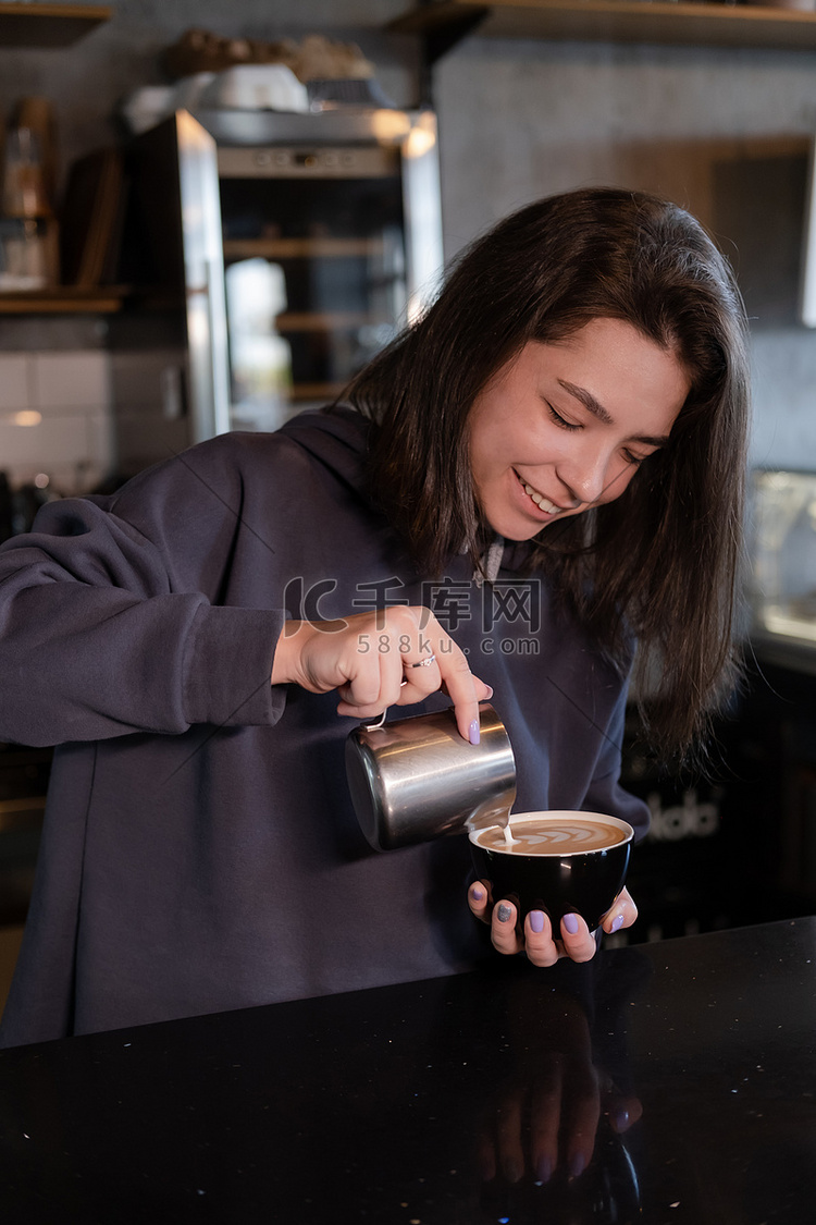可爱的女孩在咖啡店做拿铁。