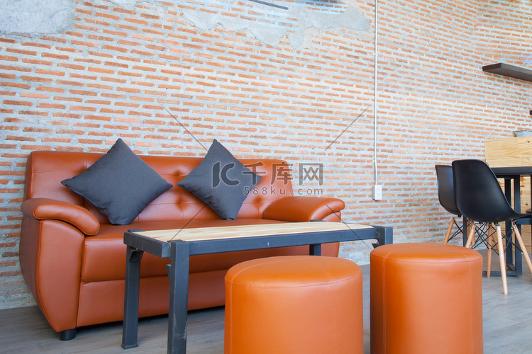 有砖墙棕色背景的皮革橙色沙发