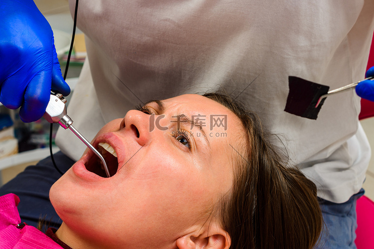 牙医用水冲洗牙齿治疗部位，洗去