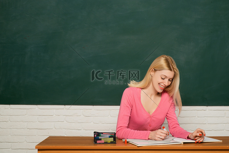 女孩可爱的老师坐在教室黑板背景