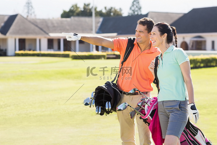 男人在背着高尔夫球包的女人身边