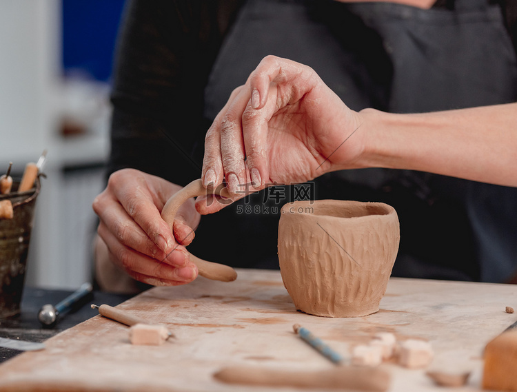 陶艺家的手用粘土做杯子