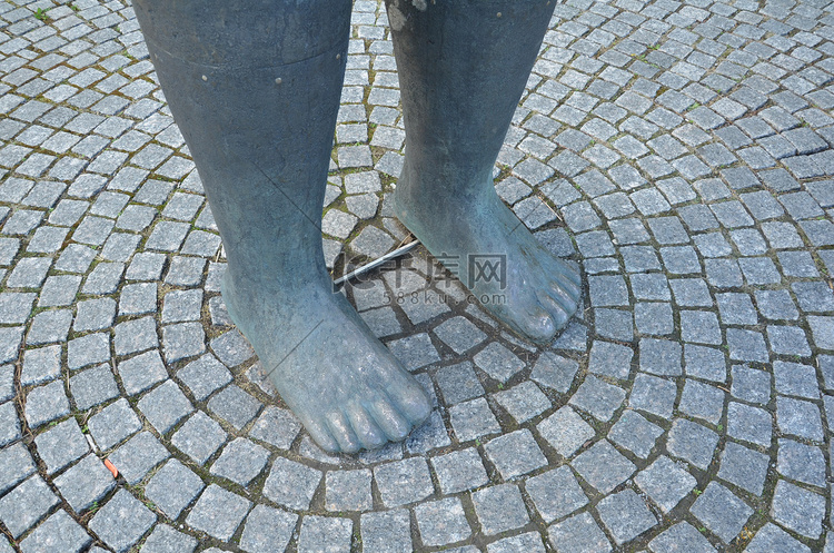 鹅卵石地面雕像的大灰色脚
