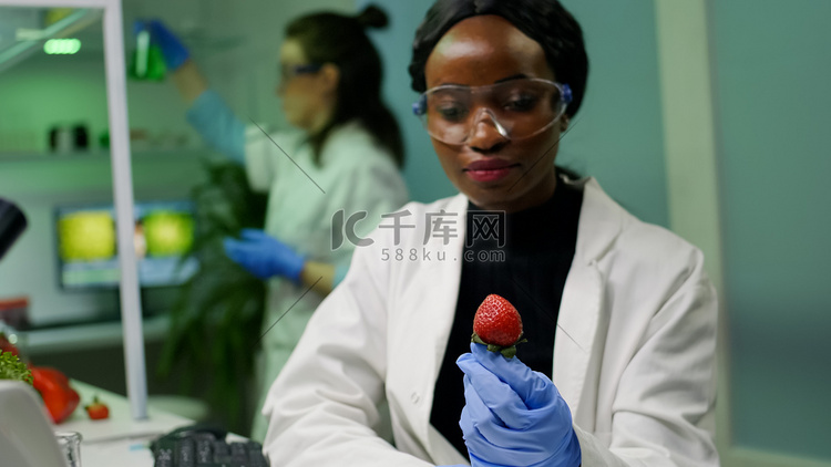 戴医用眼镜的非洲化学家看着注射