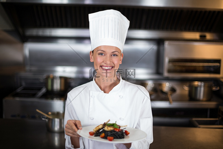 微笑的女厨师拿着盘子的肖像