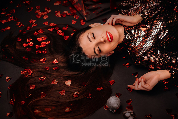 一个女孩穿着闪亮的衣服躺在地板