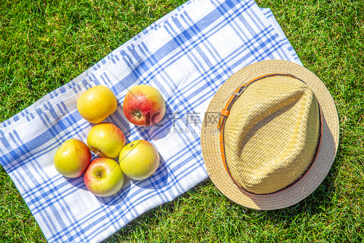 布上的红黄苹果和草帽，公园里的