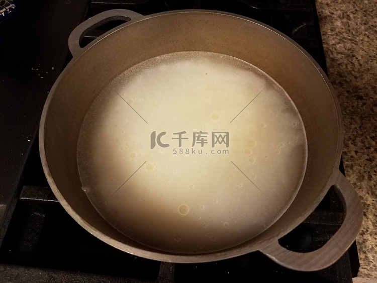 一碗米饭放在炉子上的金属锅里加
