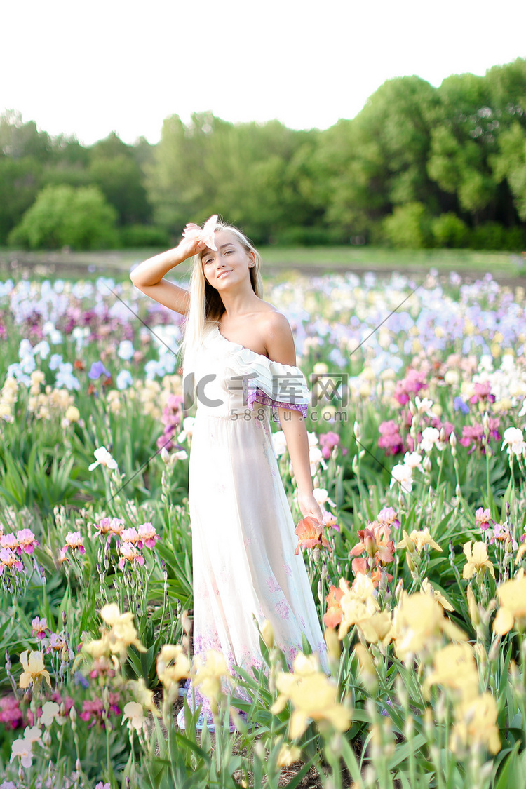 穿着白色连衣裙的年轻女孩站在花