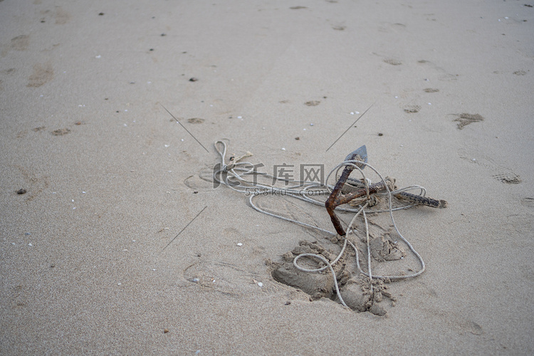 在海边的沙滩上生锈的小锚