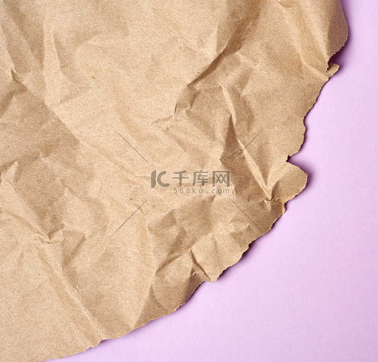 紫色背景上皱巴巴的棕色包装纸