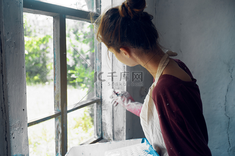 有刷子油漆窗口的妇女家庭装修内