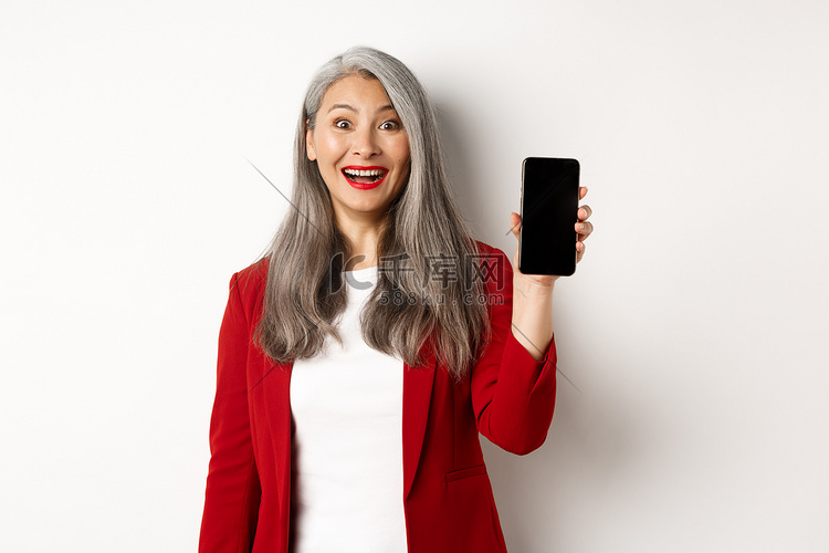 快乐的亚洲女企业家展示手机屏幕