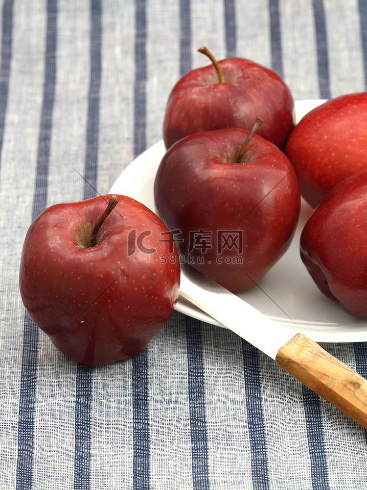 盘子里的美味苹果，条纹桌布上有