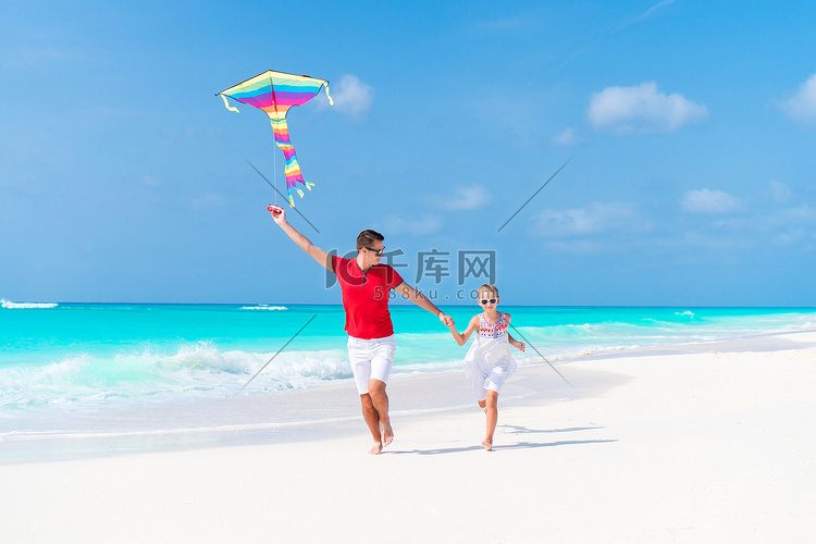一家人一起在热带白色海滩放风筝