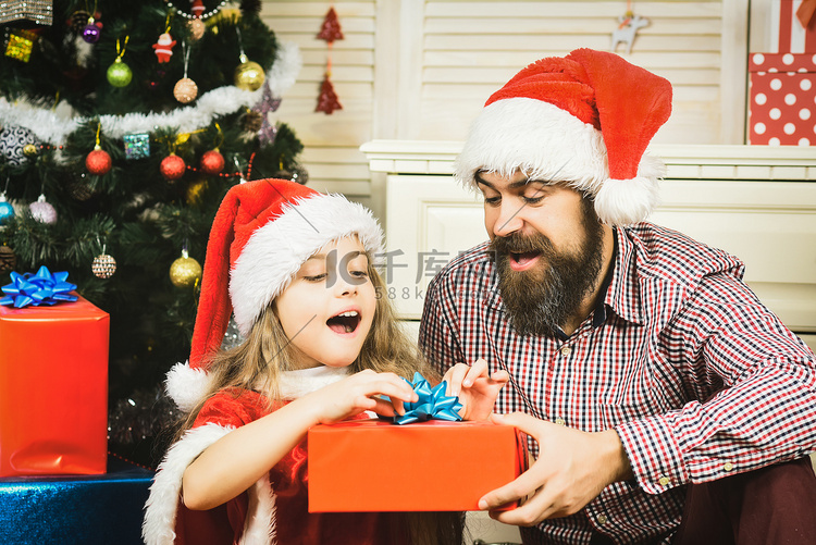 快乐的父亲和女儿在圣诞树上带着